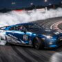 A high-performance sports car drifting through a sharp corner with tire smoke.