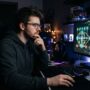 Man holding his chin while studying a hard game puzzle on a monitor.