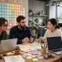 Mobile game development team planning sprint tasks around shared board